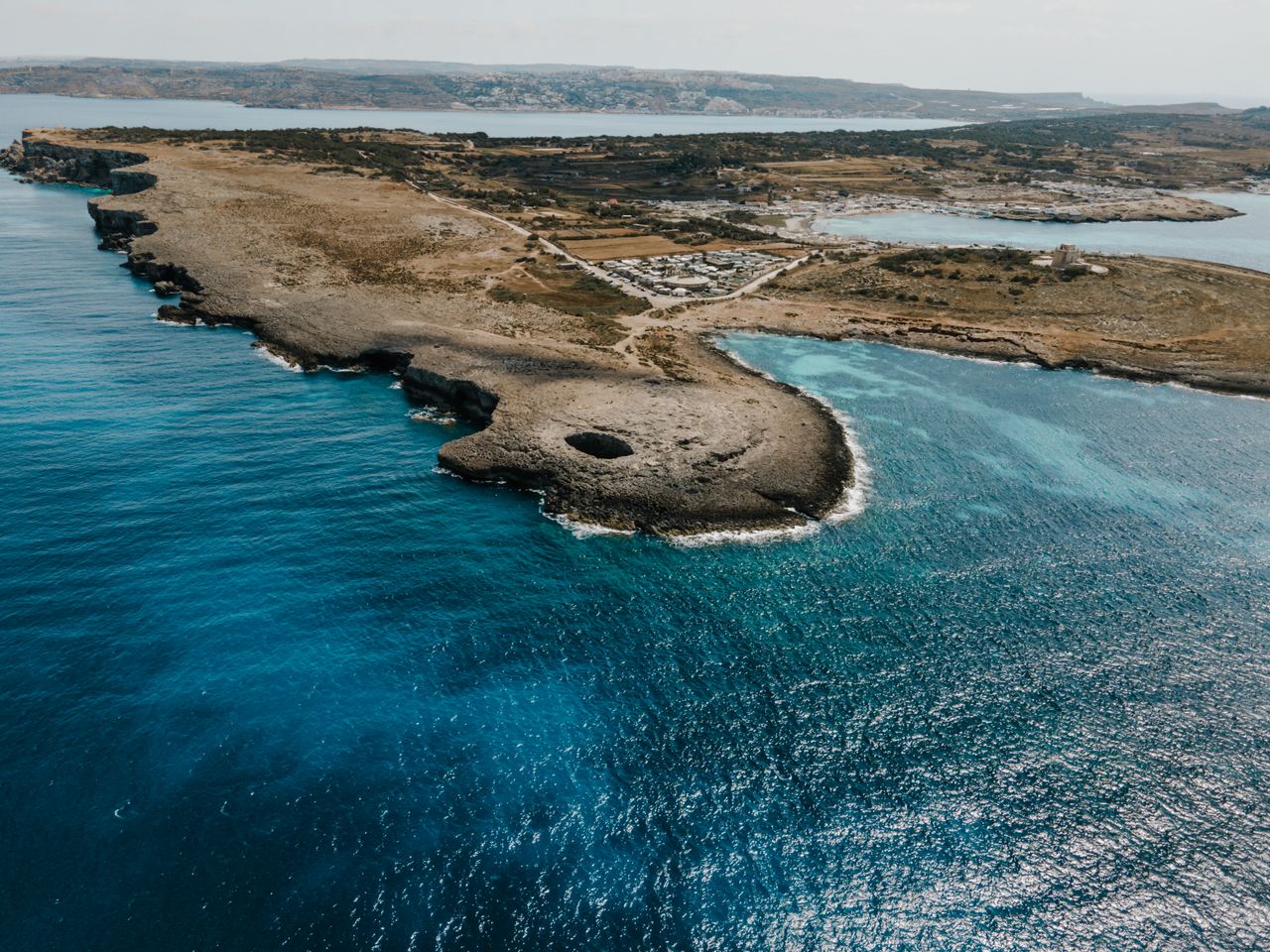 about-img A breathtaking aerial view of the Il-Mellieħa coastline in Malta, showcasing turquoise waters and rugged terrain.